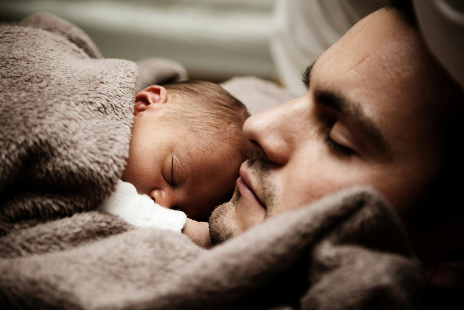 life, touching close-up of a father and his baby peacefully napping together.